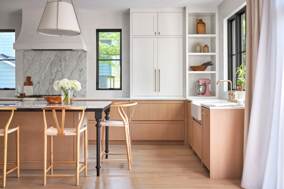 Kitchen - transitional u-shaped light wood floor kitchen idea in Ottawa with a farmhouse sink, shaker cabinets, white cabinets, marble countertops, multicolored backsplash, marble backsplash, paneled appliances, an island and multicolored countertops