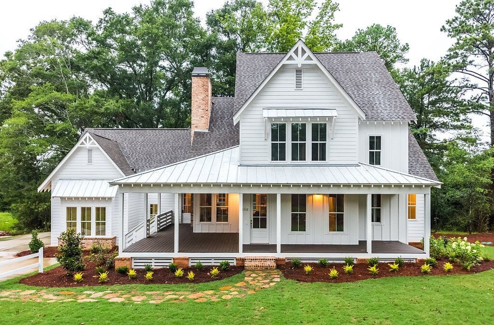 Large country two-storey white house exterior in Atlanta with a shingle roof, vinyl siding and a hip roof.