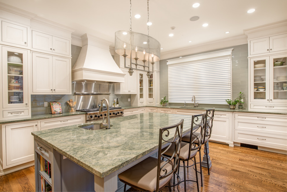 Inspiration for a large traditional u-shaped separate kitchen in Seattle with an undermount sink, beaded inset cabinets, white cabinets, granite benchtops, green splashback, glass tile splashback, stainless steel appliances, medium hardwood floors and with island.