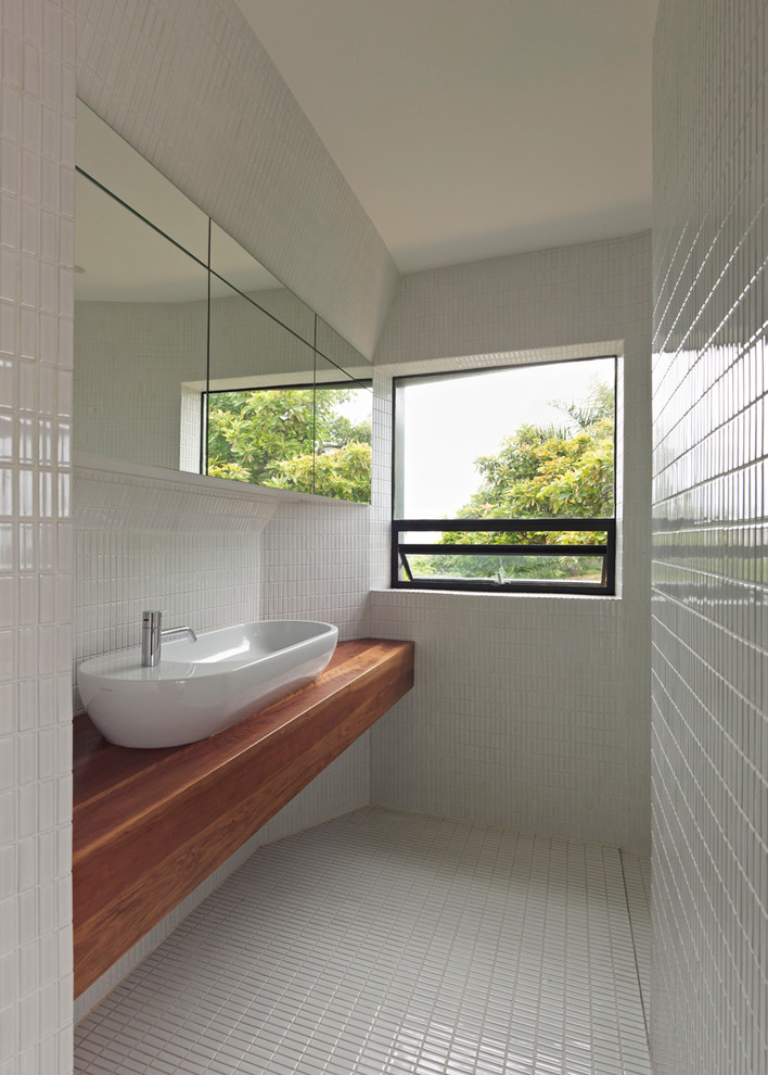 Small contemporary kids bathroom in Sydney with a vessel sink, white cabinets, wood benchtops, a freestanding tub, an alcove shower, white tile and white walls.