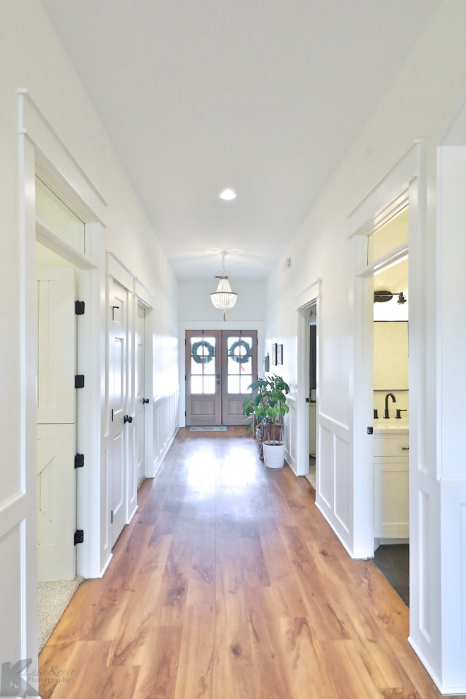 Große Landhausstil Haustür mit weißer Wandfarbe, Vinylboden, Doppeltür, dunkler Holzhaustür und braunem Boden in Sonstige