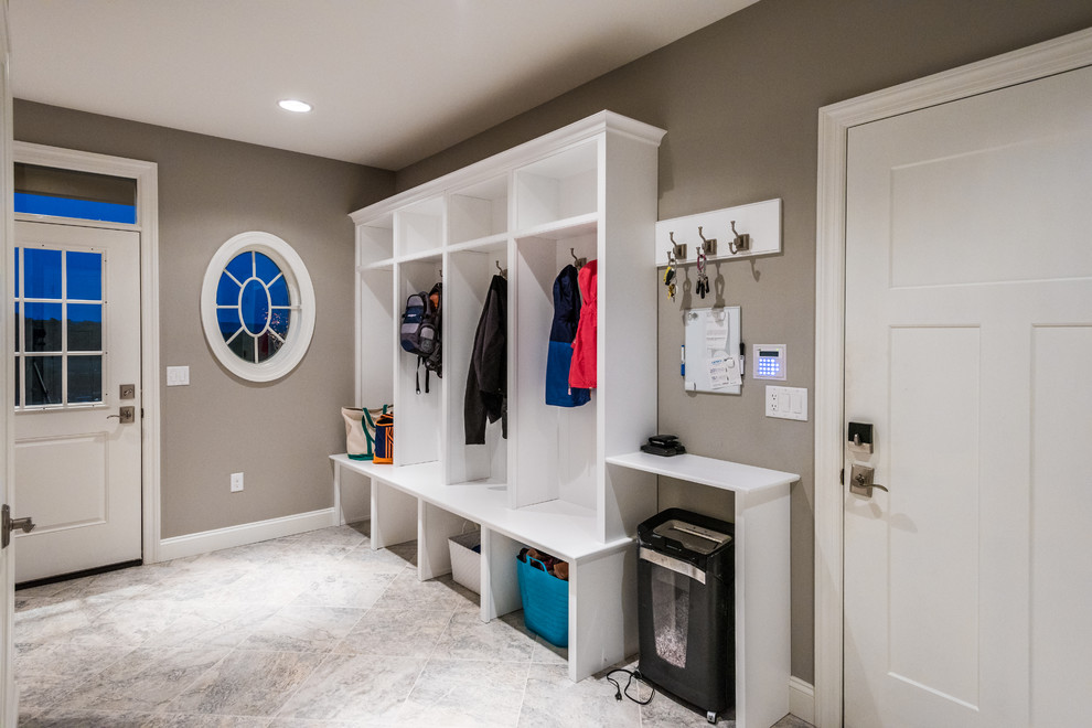 Example of a large transitional ceramic tile mudroom design with gray walls and a white front door