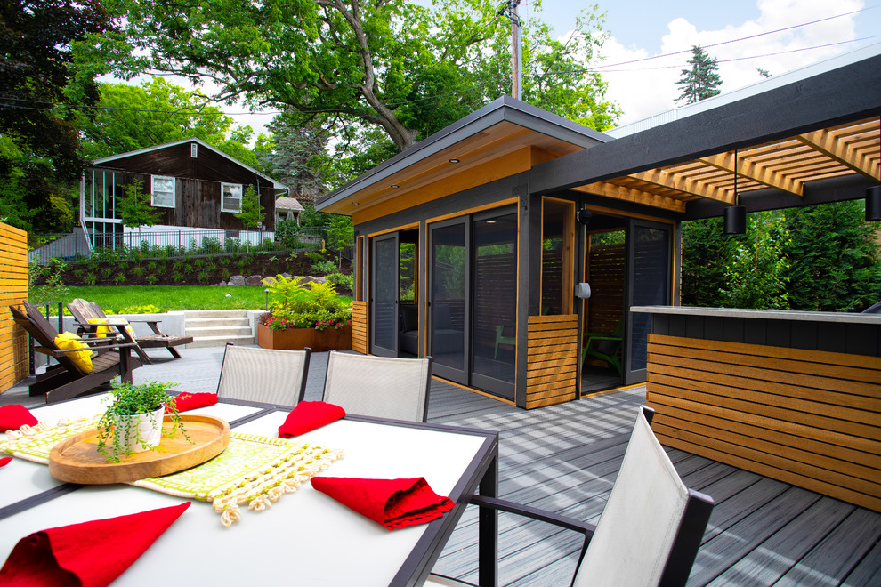 This is an example of a large modern backyard screened-in verandah in Minneapolis with decking and a pergola.