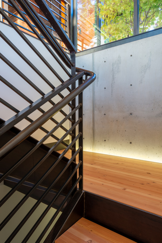 Inspiration for a mid-sized modern wood u-shaped staircase in Seattle with open risers and metal railing.