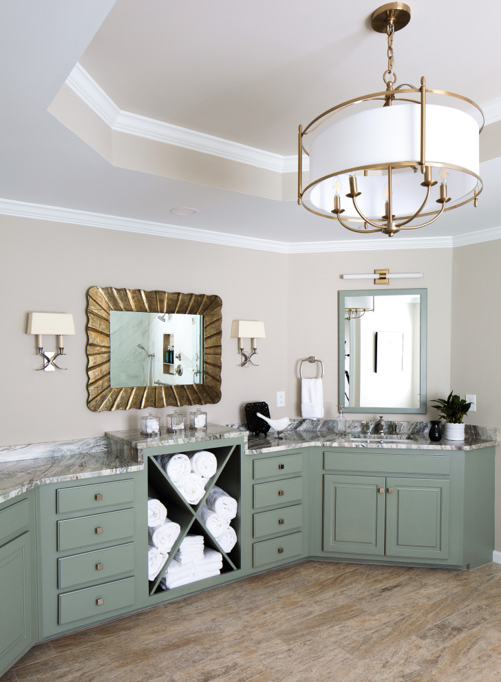 This is an example of a large transitional master bathroom in Atlanta with raised-panel cabinets, green cabinets, a freestanding tub, a corner shower, a two-piece toilet, white tile, porcelain tile, beige walls, travertine floors, an undermount sink, quartzite benchtops, beige floor, a hinged shower door, multi-coloured benchtops, a niche, a double vanity, a built-in vanity and recessed.