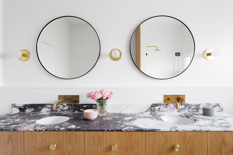 Inspiration for a large contemporary master bathroom in Melbourne with flat-panel cabinets, light wood cabinets, a freestanding tub, an alcove shower, a one-piece toilet, cement tile, cement tiles, an integrated sink, marble benchtops and black floor.