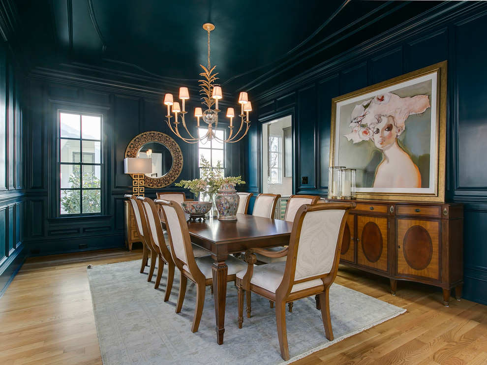 Photo of a transitional dining room in Raleigh with blue walls and light hardwood floors.