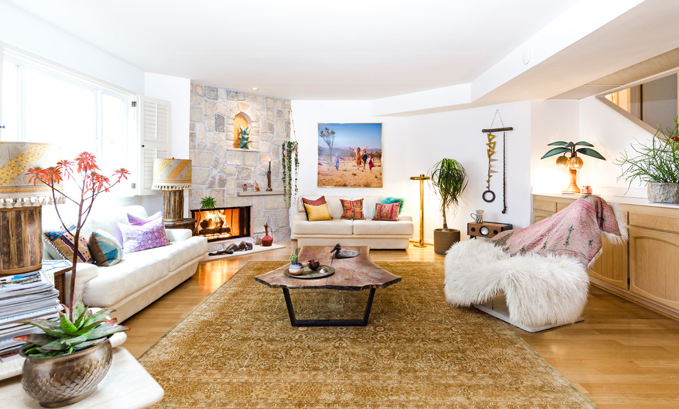 Photo of a beach style formal living room in Los Angeles with white walls, light hardwood floors, a corner fireplace, a stone fireplace surround and beige floor.