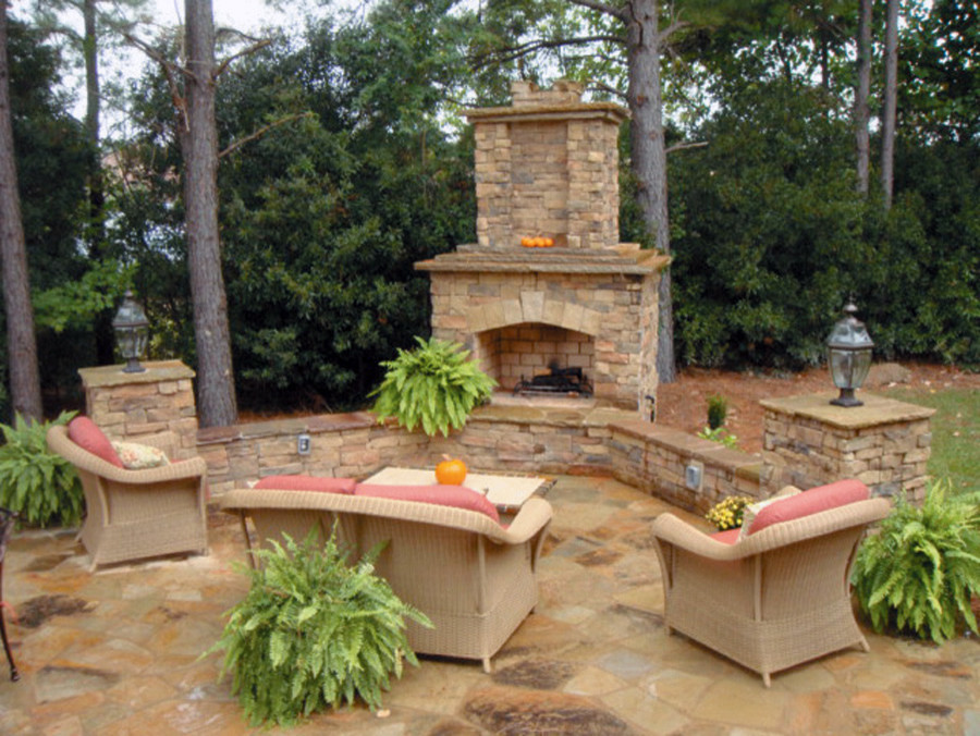 Photo of a mid-sized traditional backyard patio in Toronto with a fire feature, natural stone pavers and no cover.