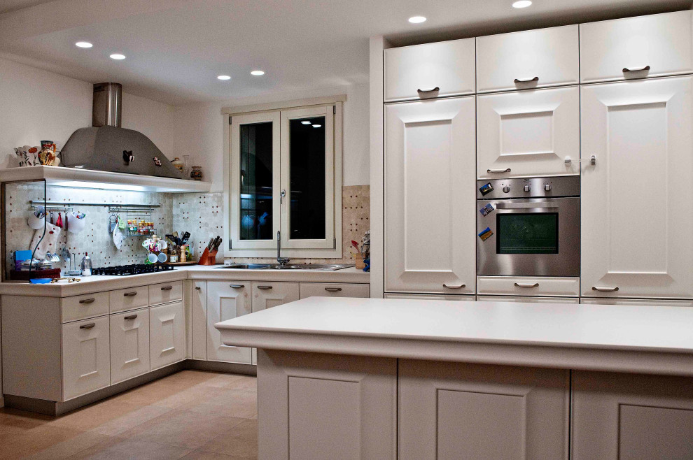 Inspiration for a large traditional l-shaped separate kitchen in Bologna with a drop-in sink, raised-panel cabinets, light wood cabinets, wood benchtops, ceramic splashback, stainless steel appliances, porcelain floors, with island, pink floor, white benchtop and recessed.
