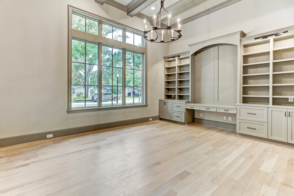 Large study room in Houston with beige walls, light hardwood floors, a built-in desk, beige floor and exposed beam.