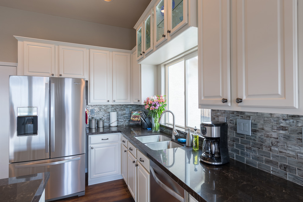 Mid-sized transitional u-shaped eat-in kitchen photo with a single-bowl sink, raised-panel cabinets, white cabinets, quartzite countertops, gray backsplash, glass tile backsplash, stainless steel appliances and an island