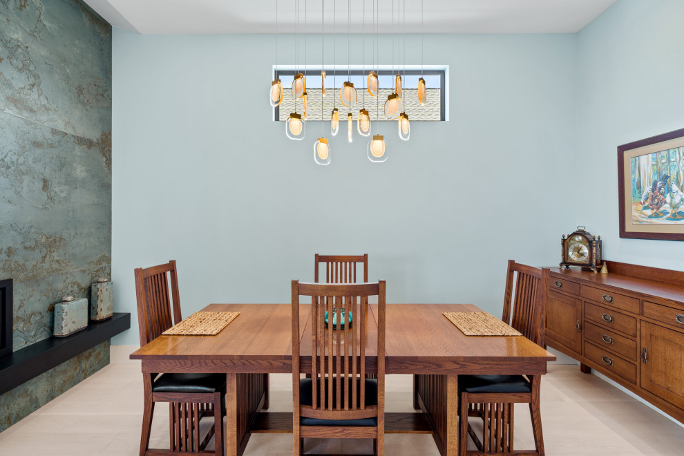 Réalisation d'une salle à manger ouverte sur le salon design avec un mur bleu, parquet clair, une cheminée ribbon, un manteau de cheminée en carrelage, un sol beige et un plafond voûté.