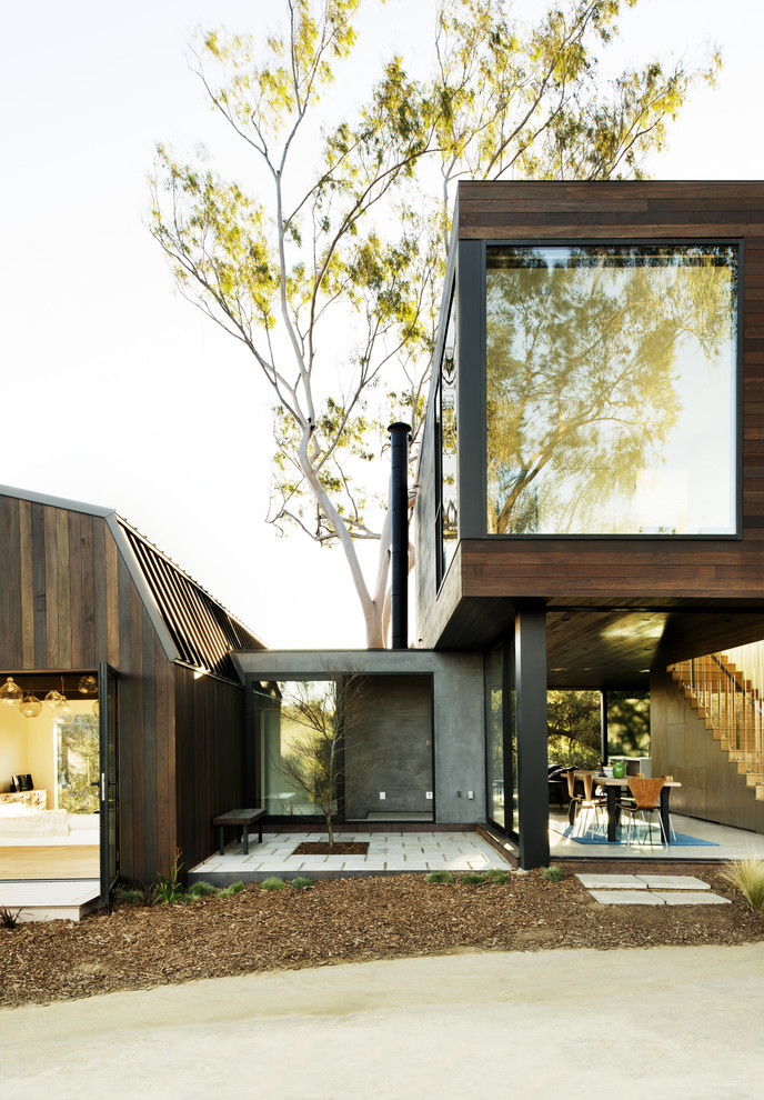 Design ideas for a mid-sized contemporary two-storey exterior in Los Angeles with wood siding and a flat roof.