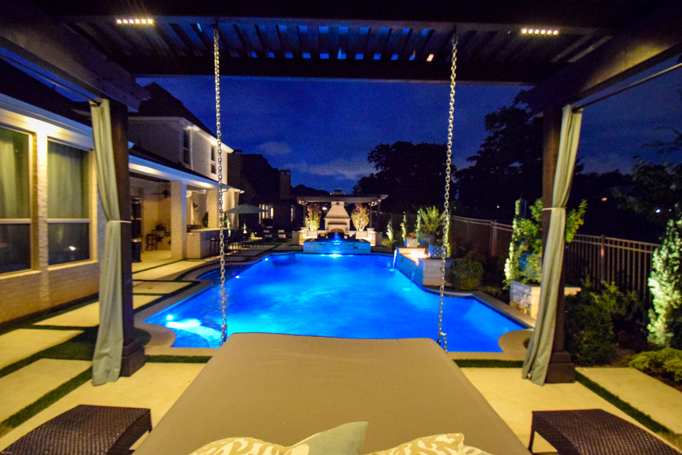 This is an example of a mid-sized contemporary backyard custom-shaped lap pool in Dallas with a water feature and natural stone pavers.