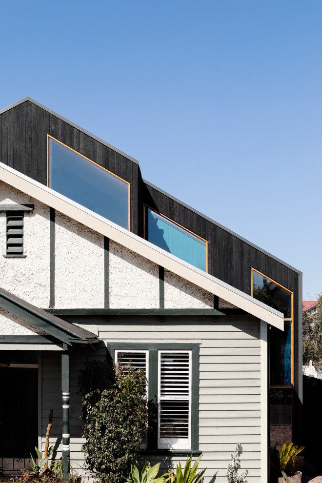 This is an example of a scandinavian two-storey house exterior in Melbourne with wood siding and a metal roof.