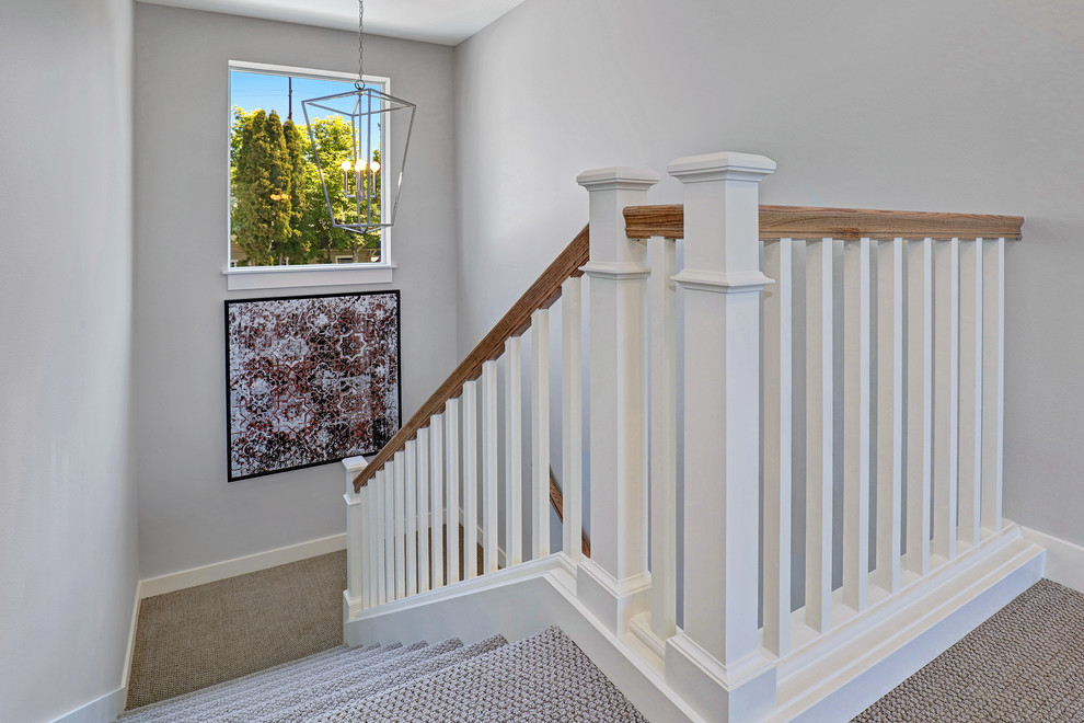 Photo of a traditional carpeted u-shaped staircase in Seattle with carpet risers and wood railing.