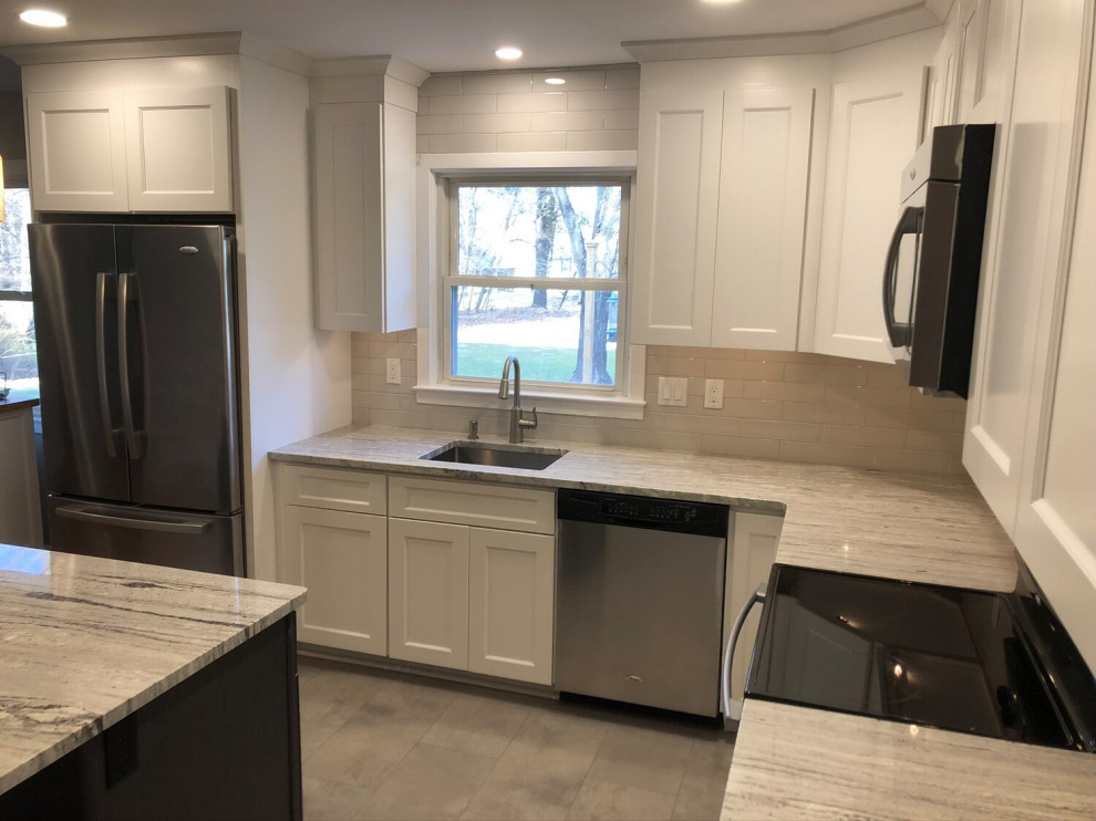 Photo of a contemporary l-shaped separate kitchen in New York with a single-bowl sink, louvered cabinets, white cabinets, granite benchtops, beige splashback, ceramic splashback, stainless steel appliances, ceramic floors, with island, grey floor and multi-coloured benchtop.
