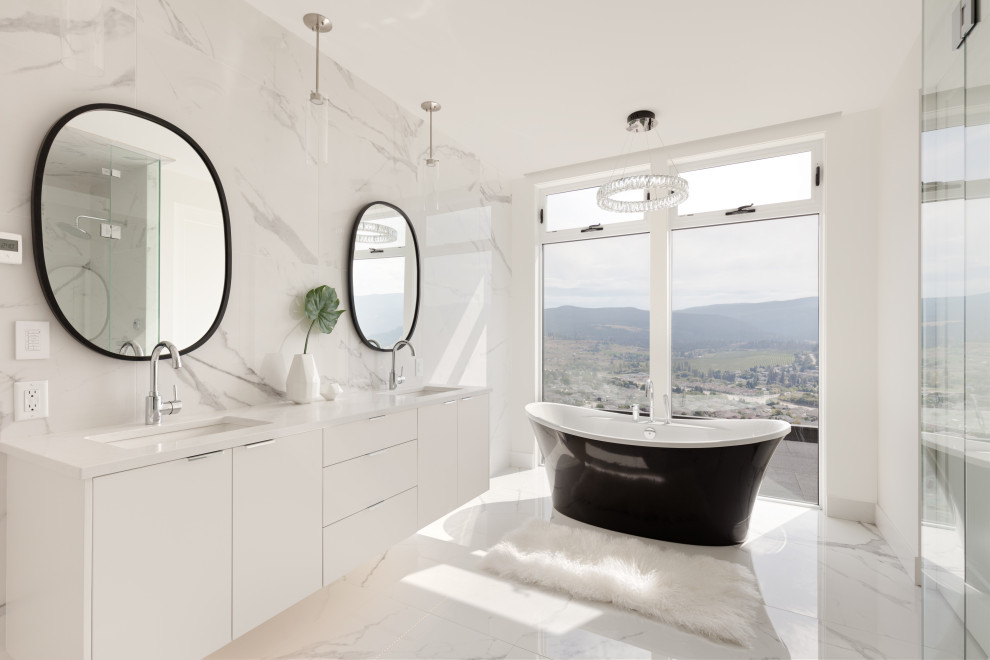 This is an example of a contemporary bathroom in Vancouver with flat-panel cabinets, white cabinets, a freestanding tub, white tile, an undermount sink, white floor, white benchtops, a double vanity and a floating vanity.