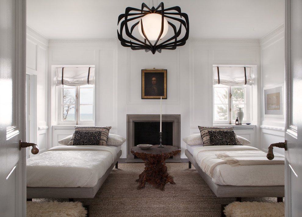 Large transitional guest bedroom in Chicago with white walls, dark hardwood floors, a stone fireplace surround and no fireplace.