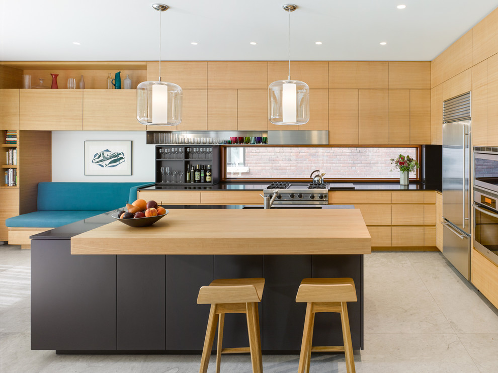 Expansive contemporary l-shaped eat-in kitchen in Toronto with an undermount sink, flat-panel cabinets, light wood cabinets, granite benchtops, black splashback, stone slab splashback, stainless steel appliances, limestone floors and with island.