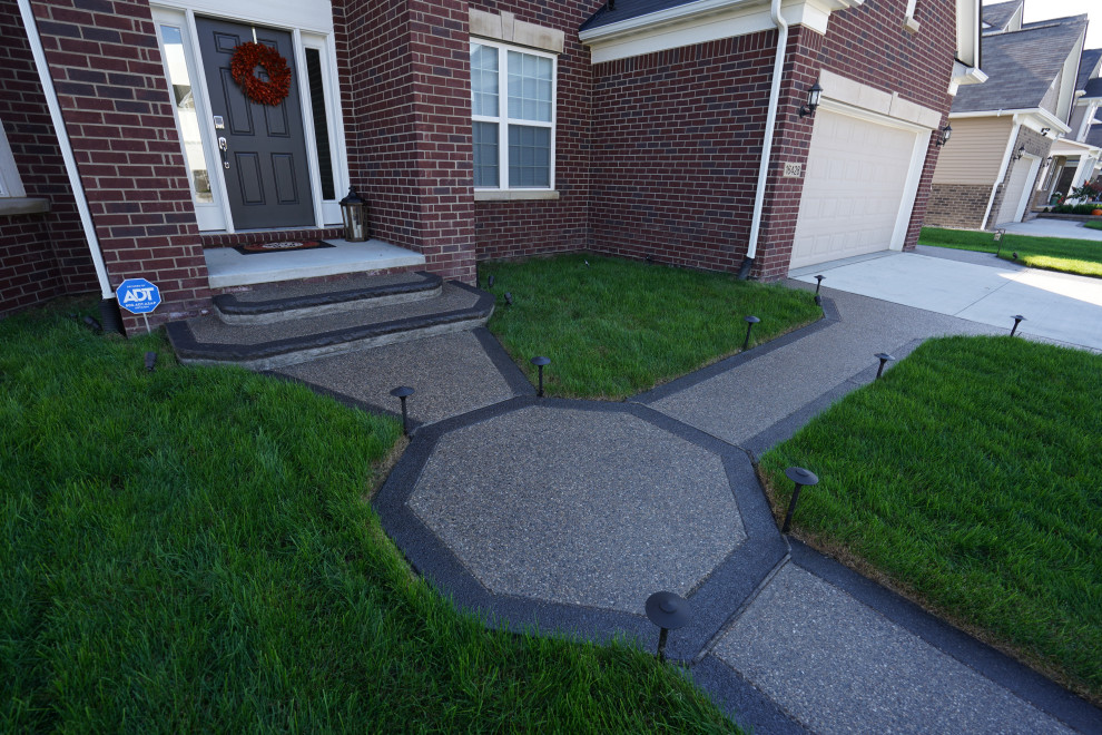 This is an example of a mid-sized modern shade front yard concrete paver walkway in Detroit.