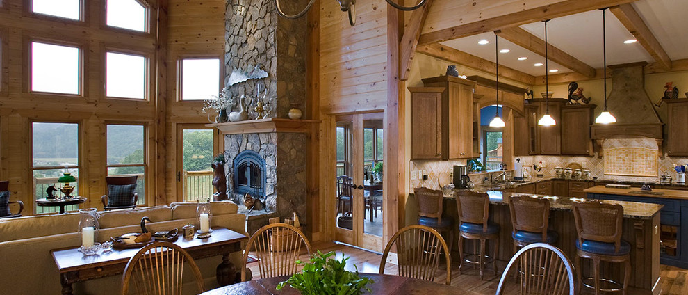 Eat-in kitchen - large rustic u-shaped medium tone wood floor eat-in kitchen idea with an undermount sink, dark wood cabinets, beige backsplash, stone tile backsplash, stainless steel appliances, an island, recessed-panel cabinets and granite countertops