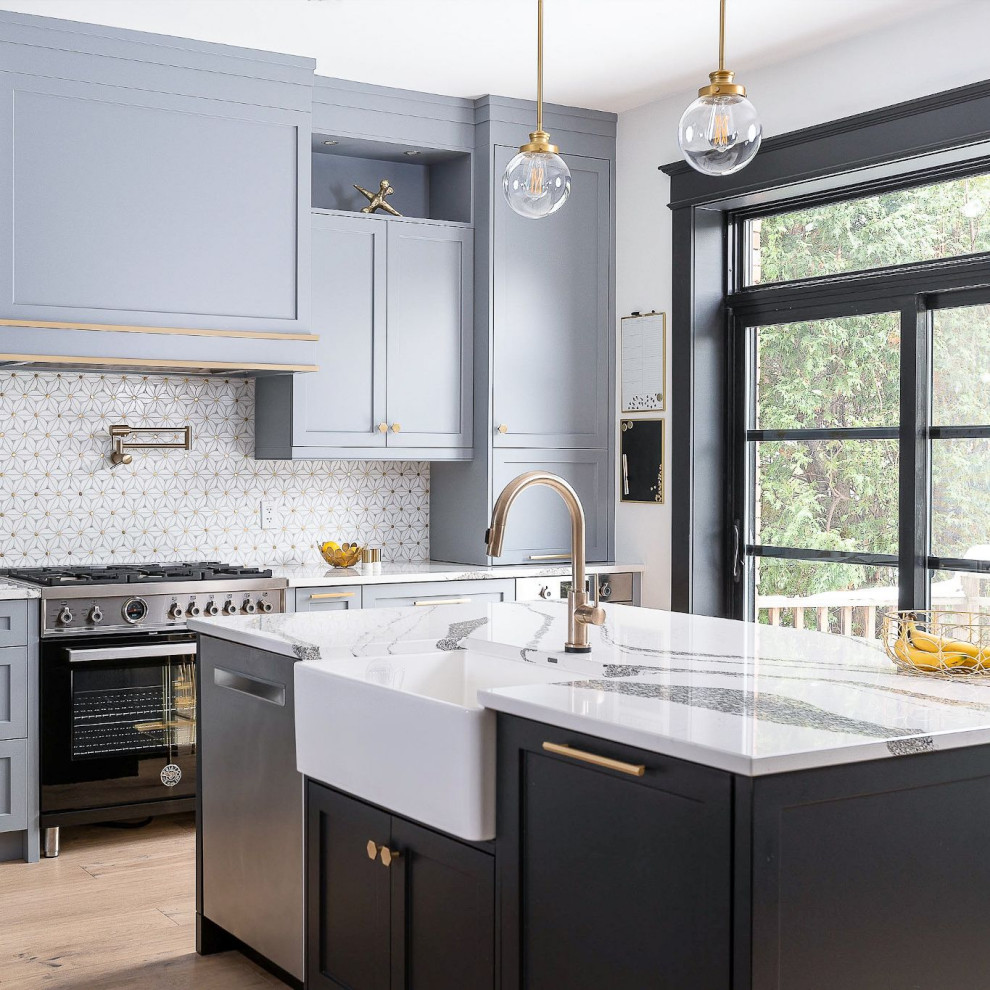 Design ideas for a transitional l-shaped kitchen in Toronto with a farmhouse sink, shaker cabinets, blue cabinets, quartz benchtops, multi-coloured splashback, light hardwood floors, with island and multi-coloured benchtop.