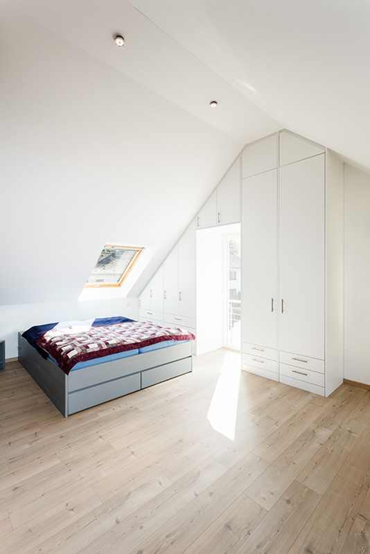 Design ideas for a modern bedroom in Cologne with light hardwood floors.