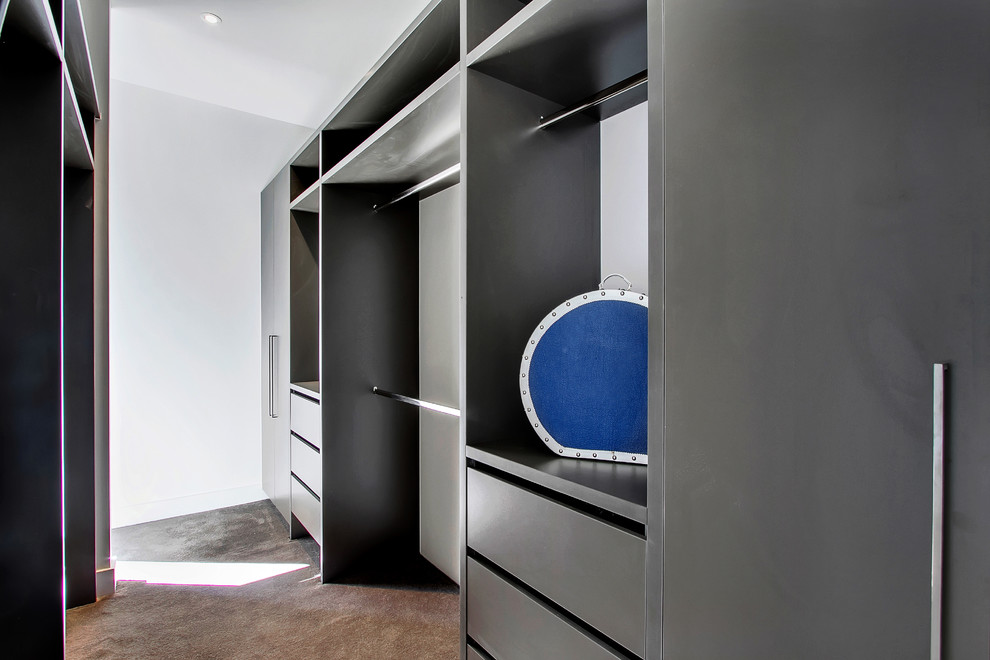 This is an example of a mid-sized contemporary gender-neutral walk-in wardrobe in Adelaide with flat-panel cabinets, grey cabinets, carpet and grey floor.