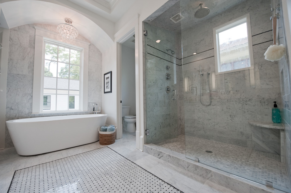 Inspiration for a large transitional master bathroom in Atlanta with shaker cabinets, white cabinets, marble benchtops, gray tile, a freestanding tub, a two-piece toilet, an undermount sink, white walls, marble floors, an alcove shower, grey floor, a hinged shower door and stone tile.