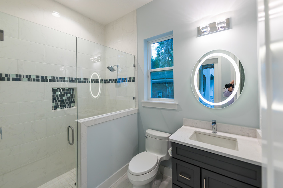Photo of a mid-sized mediterranean kids bathroom in Jacksonville with shaker cabinets, grey cabinets, white tile, porcelain tile, grey walls, an undermount sink, engineered quartz benchtops, white benchtops, an alcove shower, a one-piece toilet, porcelain floors, white floor and a hinged shower door.