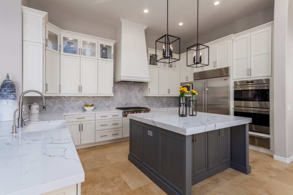 Eat-in kitchen - large transitional u-shaped travertine floor and beige floor eat-in kitchen idea in Phoenix with a farmhouse sink, shaker cabinets, white cabinets, quartz countertops, gray backsplash, ceramic backsplash, stainless steel appliances, an island and white countertops