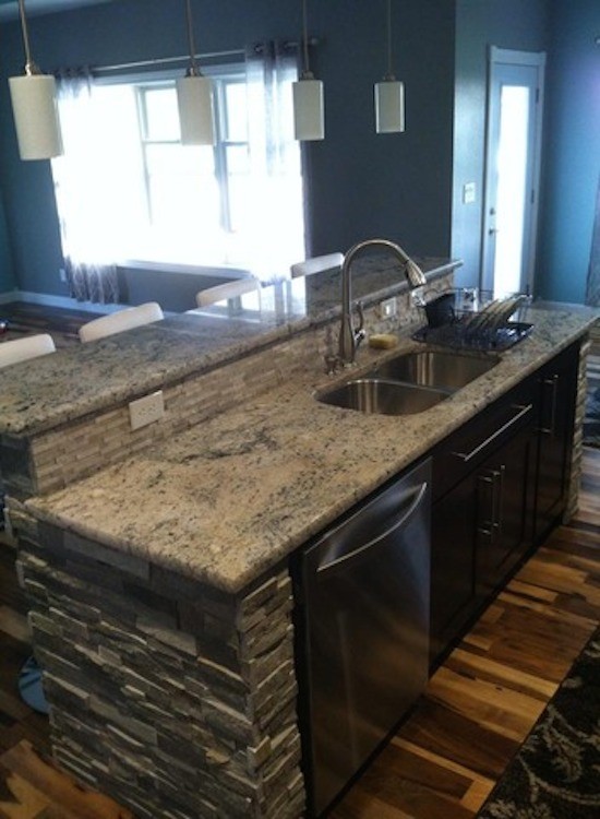 Enclosed kitchen - large galley light wood floor enclosed kitchen idea in Cedar Rapids with a drop-in sink, beaded inset cabinets, black cabinets, multicolored backsplash, stainless steel appliances and an island