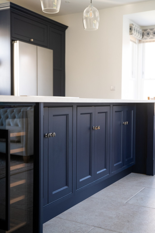 Mid-sized industrial galley eat-in kitchen in Cambridgeshire with an integrated sink, shaker cabinets, blue cabinets, quartzite benchtops, stainless steel appliances, limestone floors, with island, grey floor and grey benchtop.