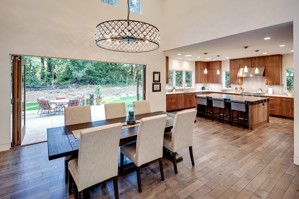 Photo of a mid-sized contemporary open plan dining in Portland with white walls, dark hardwood floors and brown floor.