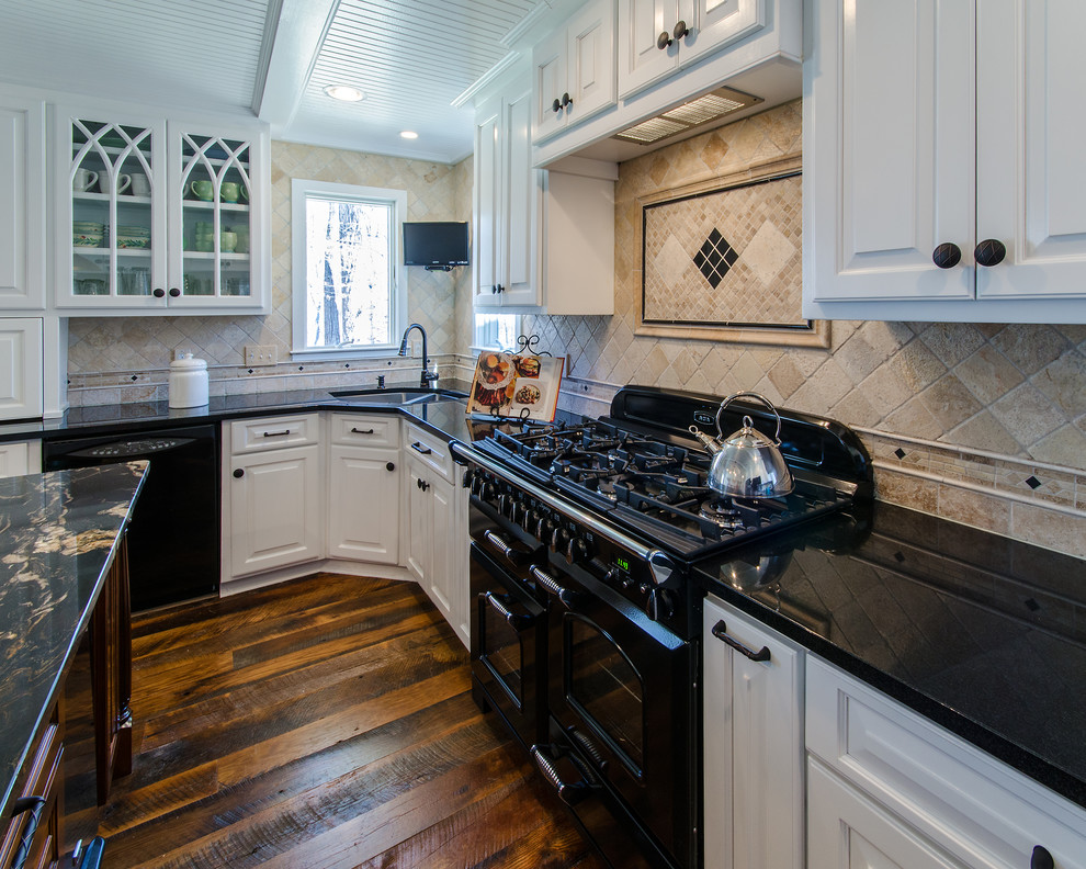 Exempel på ett mellanstort lantligt kök, med en dubbel diskho, luckor med upphöjd panel, vita skåp, granitbänkskiva, brunt stänkskydd, stänkskydd i porslinskakel, svarta vitvaror, mörkt trägolv och en köksö