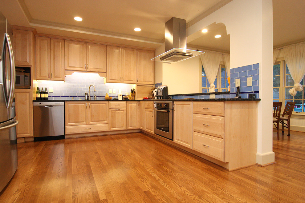 Open concept kitchen - huge transitional l-shaped medium tone wood floor open concept kitchen idea with an undermount sink, raised-panel cabinets, light wood cabinets, granite countertops, blue backsplash, glass tile backsplash and stainless steel appliances