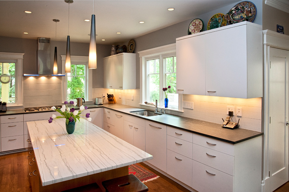 Inspiration for a mid-sized contemporary eat-in kitchen in Boston with an undermount sink, flat-panel cabinets, white cabinets, quartzite benchtops, white splashback, porcelain splashback, stainless steel appliances and medium hardwood floors.
