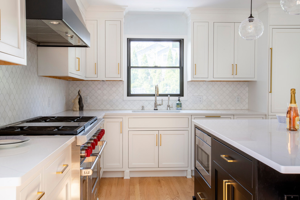 Inspiration for a mid-sized transitional l-shaped light wood floor eat-in kitchen remodel in New York with shaker cabinets, white cabinets, quartz countertops, white backsplash, paneled appliances, an island and white countertops