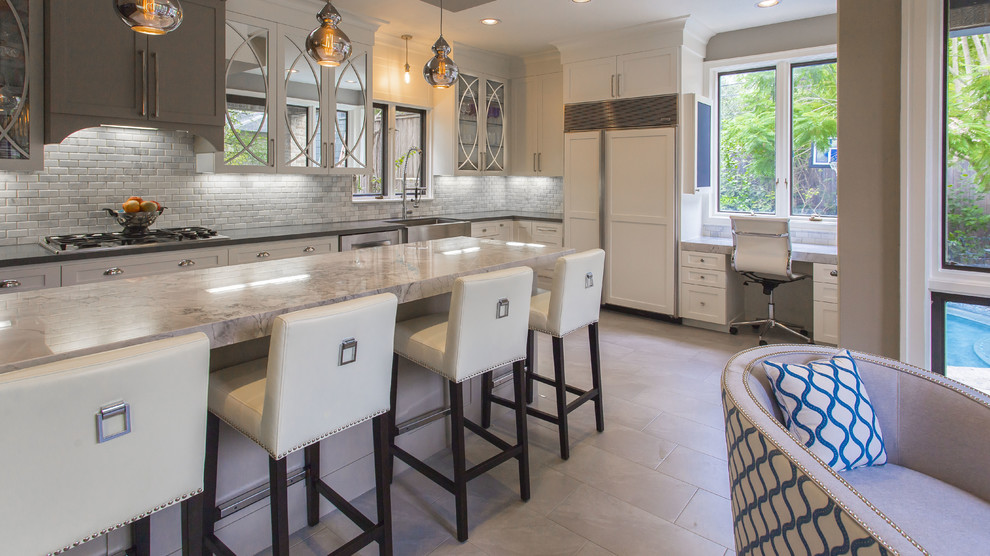 This is an example of a large eclectic single-wall open plan kitchen in Houston with a farmhouse sink, glass-front cabinets, white cabinets, quartzite benchtops, white splashback, mosaic tile splashback, ceramic floors and a peninsula.