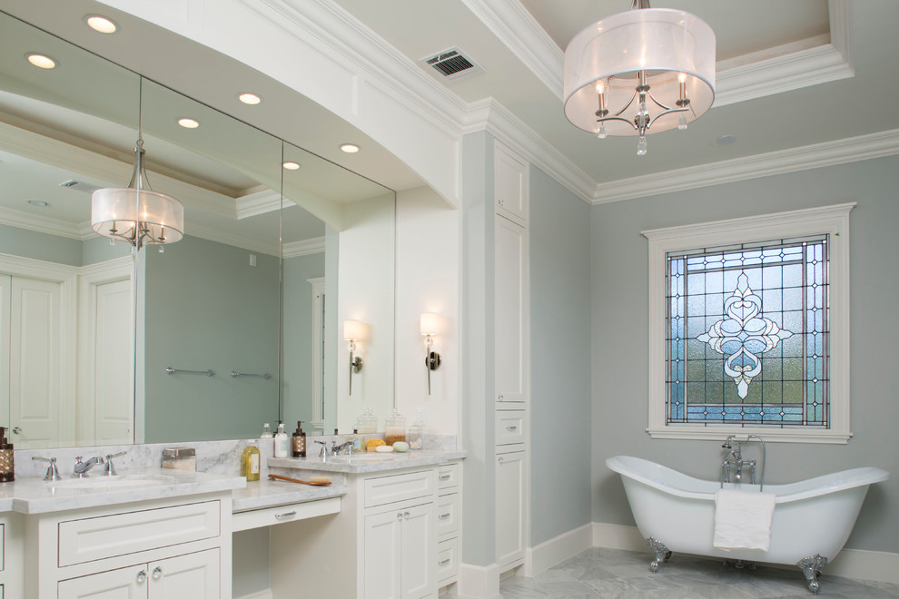 This is an example of an expansive transitional master bathroom in Houston with recessed-panel cabinets, white cabinets, a claw-foot tub, grey walls, marble floors, marble benchtops, grey floor, grey benchtops, a double vanity, a built-in vanity and coffered.