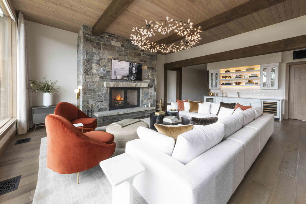 Design ideas for a country living room in Other with white walls, medium hardwood floors, a standard fireplace, a stone fireplace surround and brown floor.