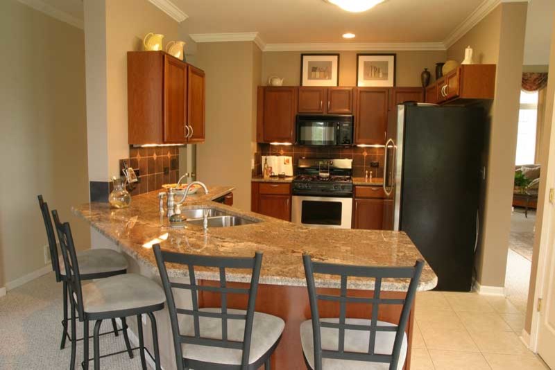 Kitchen pantry - transitional u-shaped medium tone wood floor kitchen pantry idea in Chicago with raised-panel cabinets, medium tone wood cabinets and granite countertops