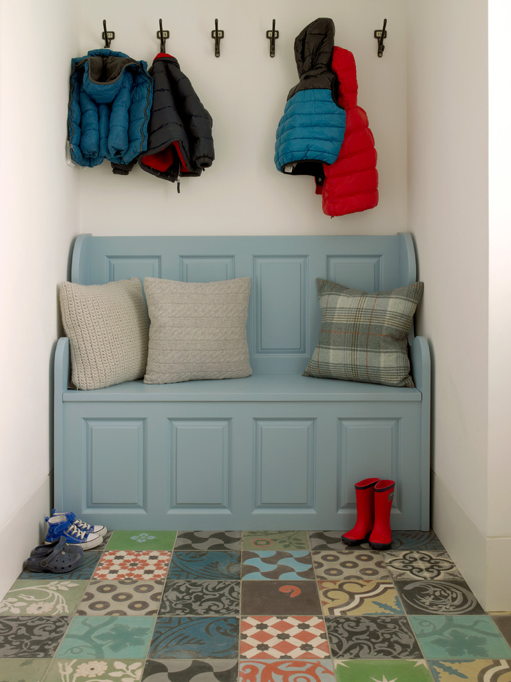 This is an example of a traditional mudroom in London with white walls and multi-coloured floor.