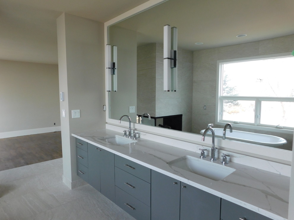 Photo of a mid-sized modern master bathroom in Calgary with flat-panel cabinets, grey cabinets, multi-coloured tile, mirror tile, grey walls, ceramic floors, a drop-in sink, granite benchtops and grey floor.