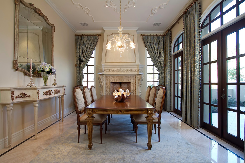 Inspiration for a large traditional separate dining room in Phoenix with beige walls, marble floors, a standard fireplace, a wood fireplace surround and beige floor.