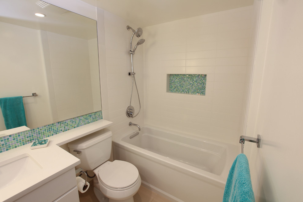 Mid-sized midcentury bathroom in Seattle with flat-panel cabinets, white cabinets, an alcove tub, a shower/bathtub combo, a two-piece toilet, white tile, porcelain tile, white walls, porcelain floors, an undermount sink and engineered quartz benchtops.