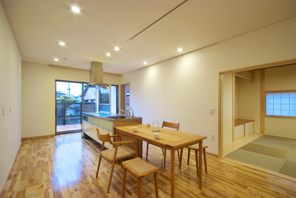 Esempio di una sala da pranzo minimalista di medie dimensioni con pareti bianche, pavimento in legno massello medio, soffitto in carta da parati e carta da parati