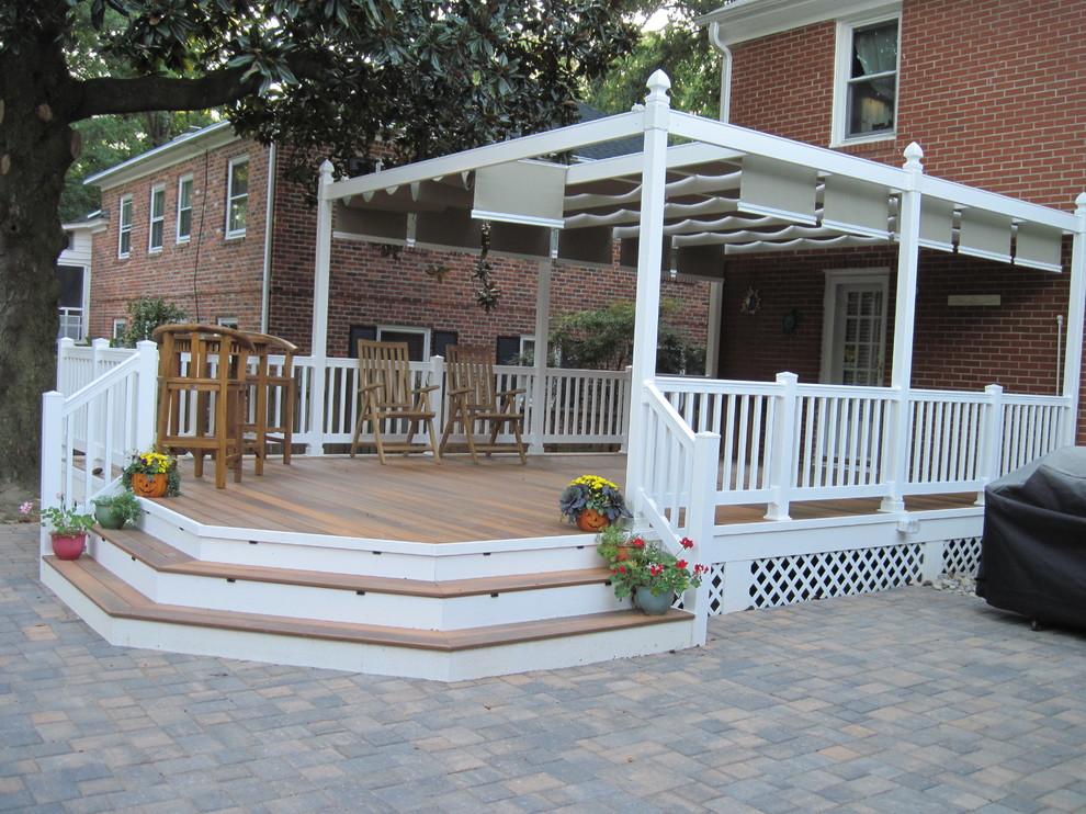 Example of a mid-sized transitional backyard deck design with a pergola